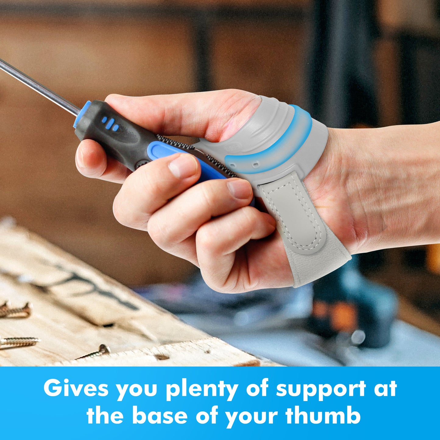 Hand wearing a gray Fortemotus thumb brace grips a screwdriver, demonstrating stable support at the base of the thumb for DIY tasks